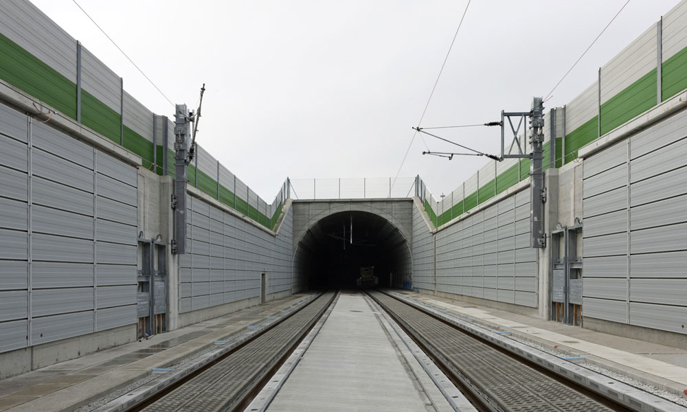 Blick auf den Tunnel, auf beiden Seiten sind Lärmschutzwände